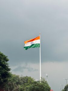 Indian national flag waving against a cloudy sky, symbolizing pride and patriotism.