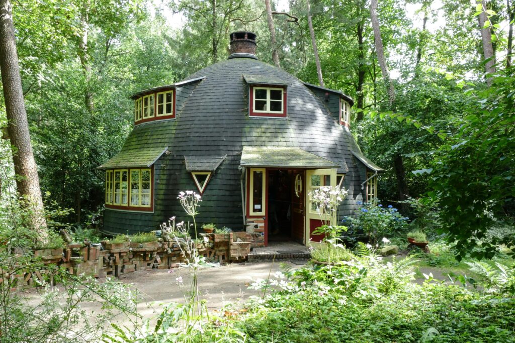 Cozy rounded house nestled in a lush green forest, perfect for nature lovers.