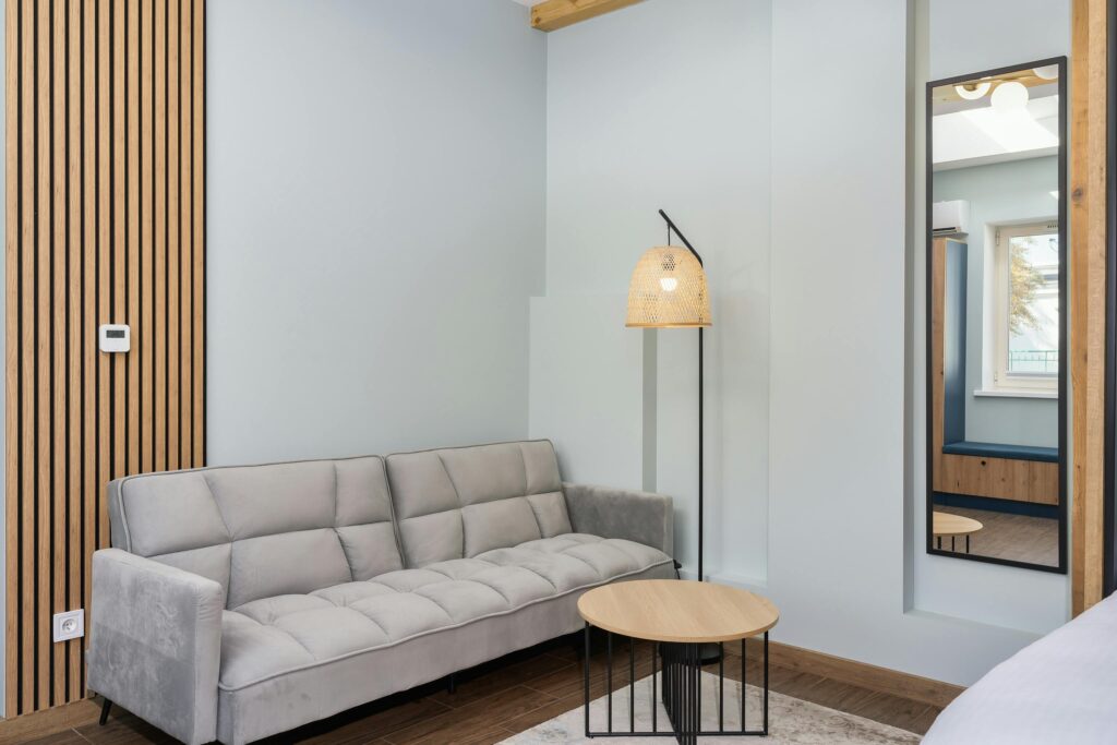 Stylish living room with a gray sofa, wooden decor, and warm lighting.
