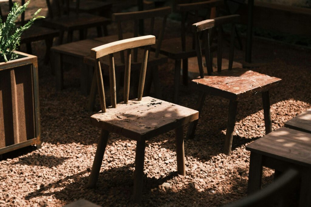 Old wooden chairs in an outdoor garden, creating a rustic and serene atmosphere.