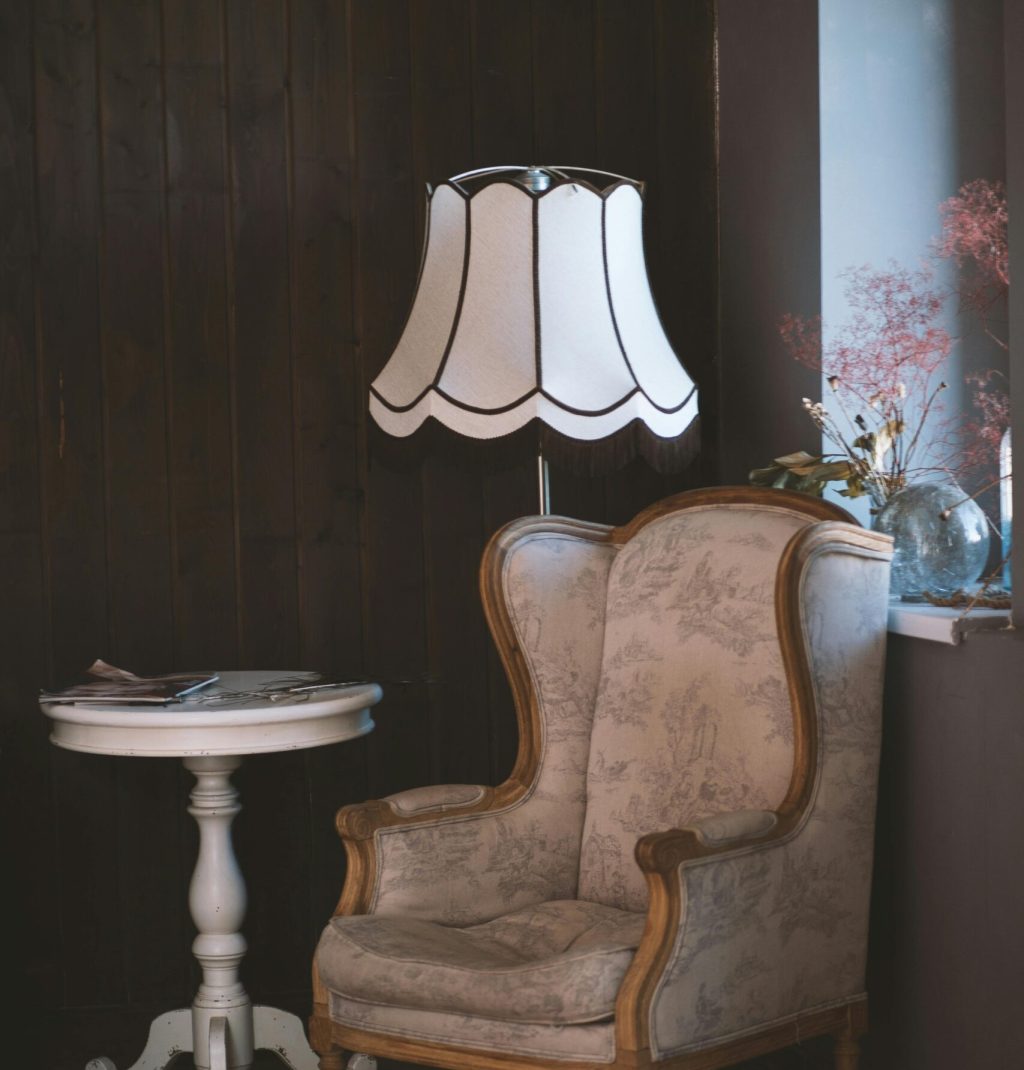 Charming vintage interior with an armchair, elegant lamp, and side table. Perfect for cozy settings.